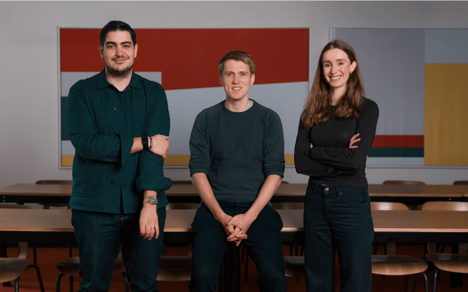 Three members of the Elyos AI team standing in an office