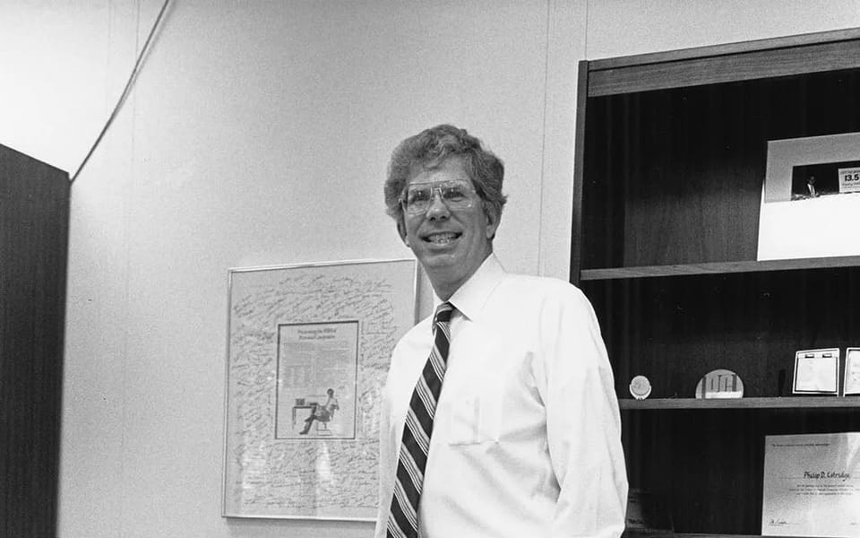 Don Estridge, who led the IBM PC project, leaning on a desk beside an IBM PC
