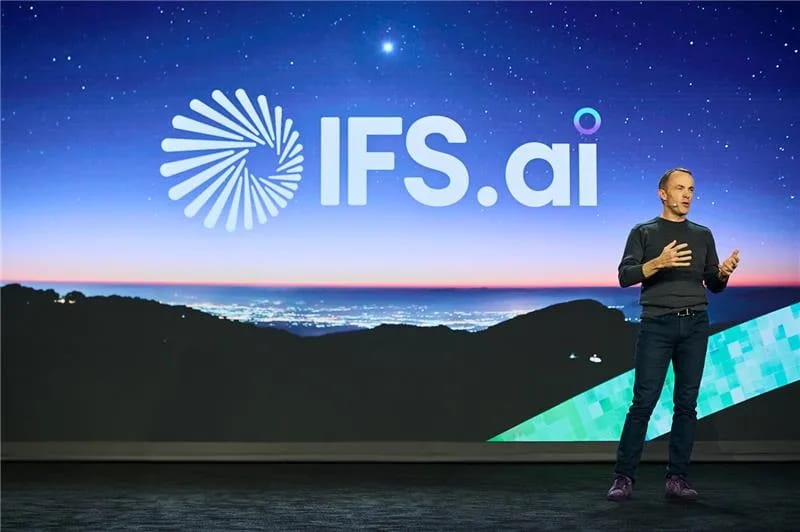 Mark Moffat, chief executive of IFS, speaking on stage in front of an IFS.ai screen