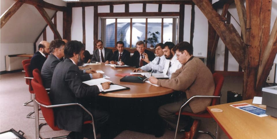 Arm's early team in a meeting at the company's timber-framed barn office