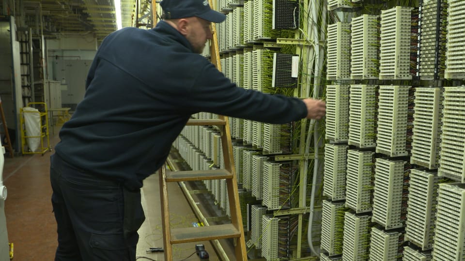 An engineer working on copper line connections in an Openreach telephone exchange