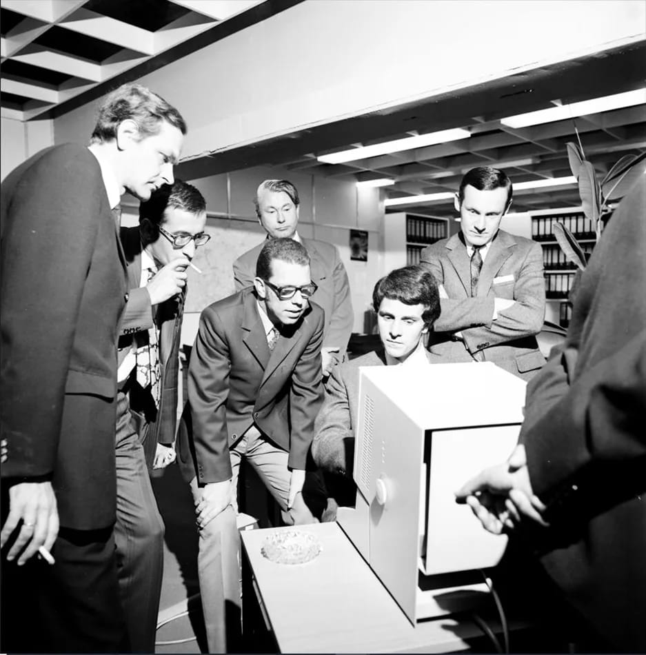 Hasso Plattner, seated, shows a real-time screen application to colleagues from IBM and ICI in 1971